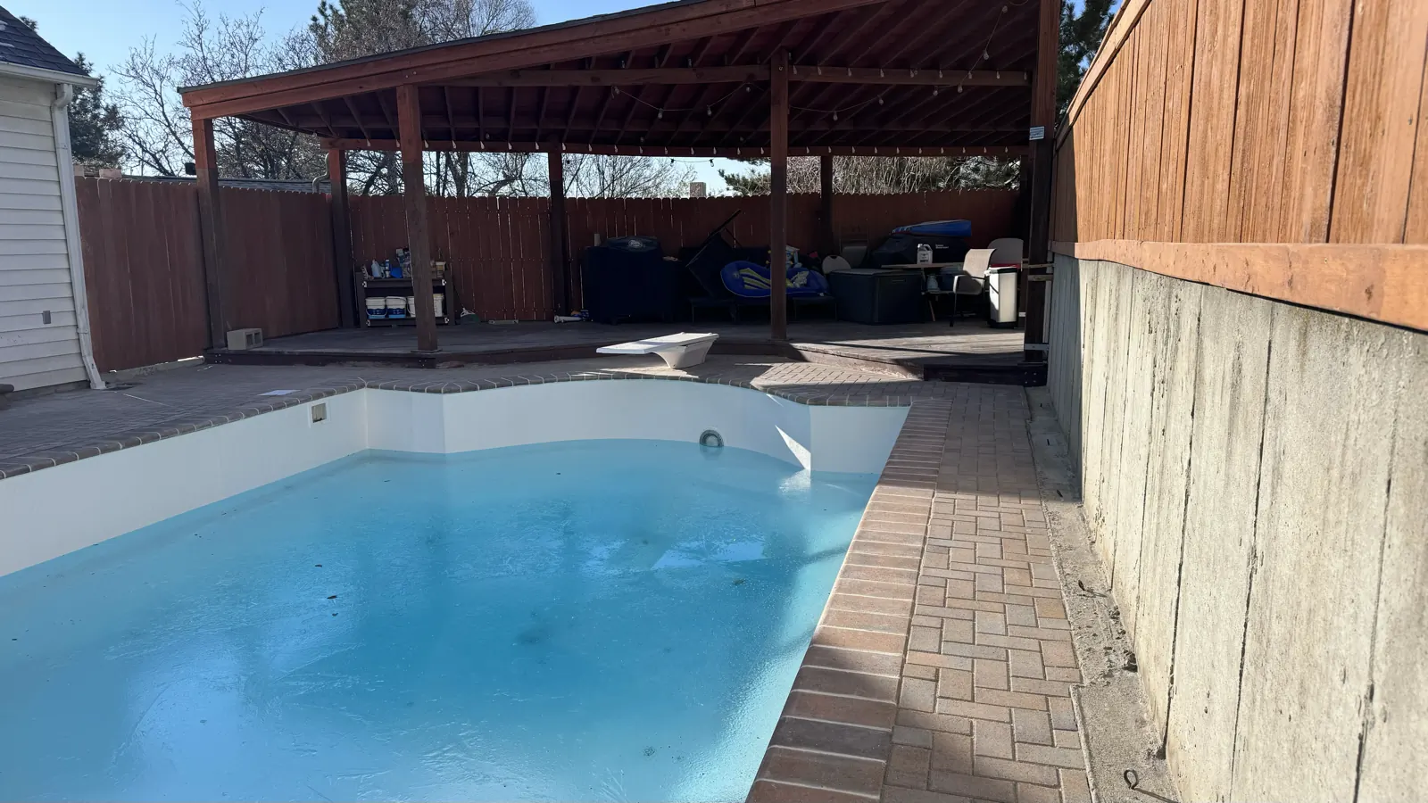 Backyard pool with a paver deck and pergola